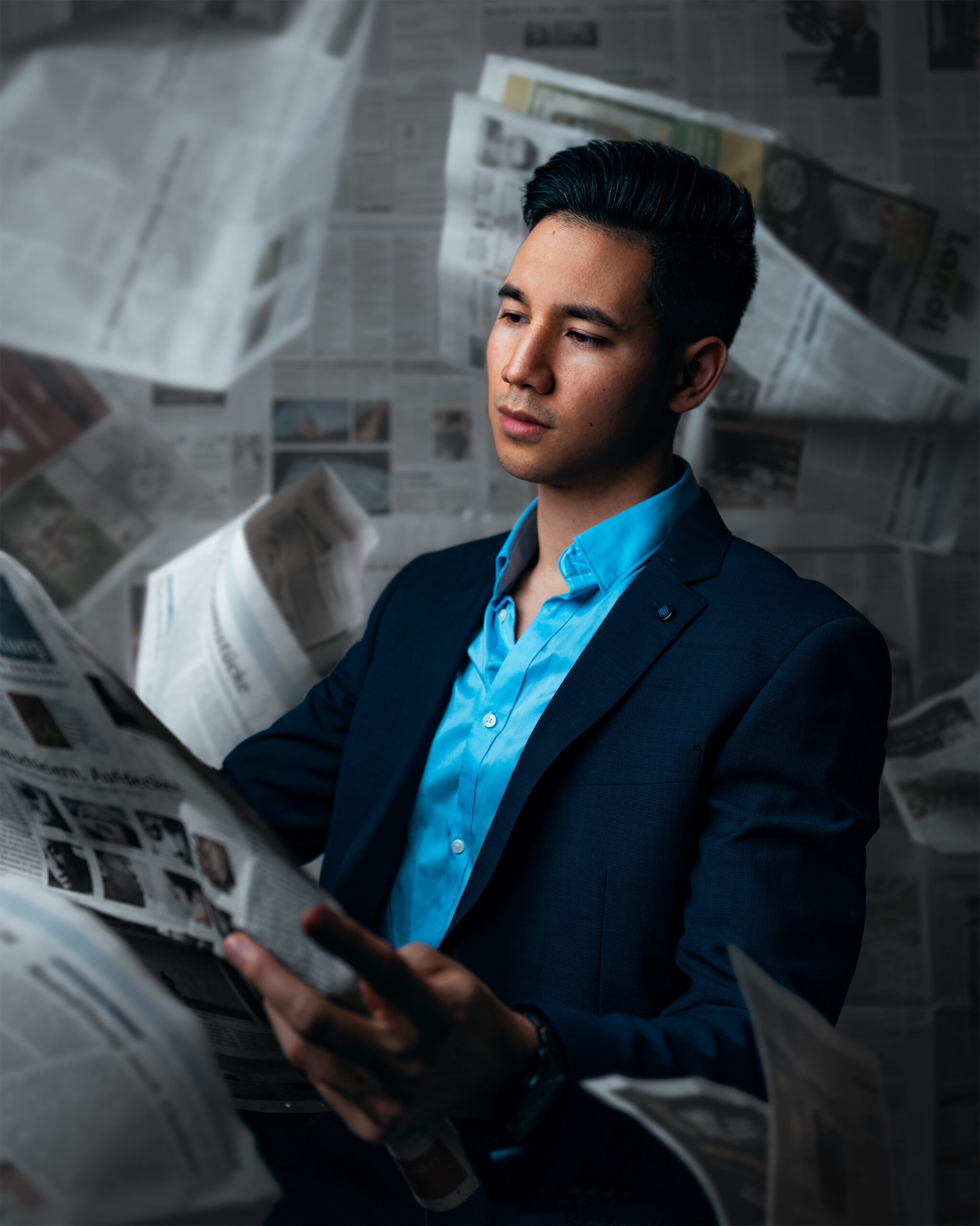A man wearing a suit in front of a newspaper background
