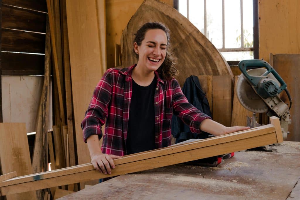 pexels-photo-8447888-8447888 A happy woman in a plaid shirt working with wood in an indoor carpentry workshop.