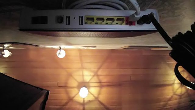 När man ser Routern underifrån framgår det att LAN-kabeln är "undangömd" bakom Routern och hänger över samma två skruvar som håller Routern på väggen. Installation av Telia Internet router och anslutning till fiberoptikdosan hos en kund på Djursholm.