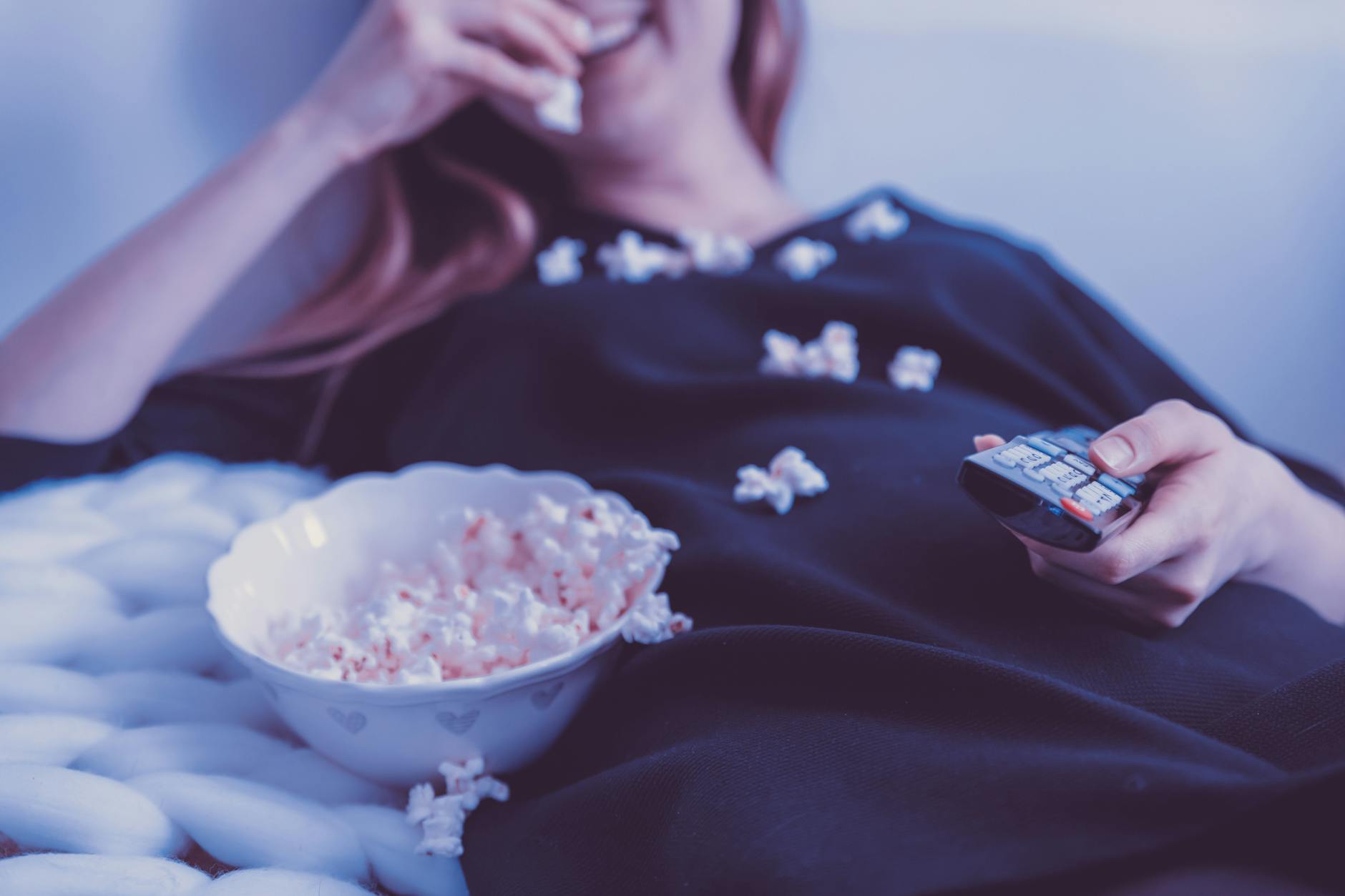 woman wearing black dress shirt eating popcorn