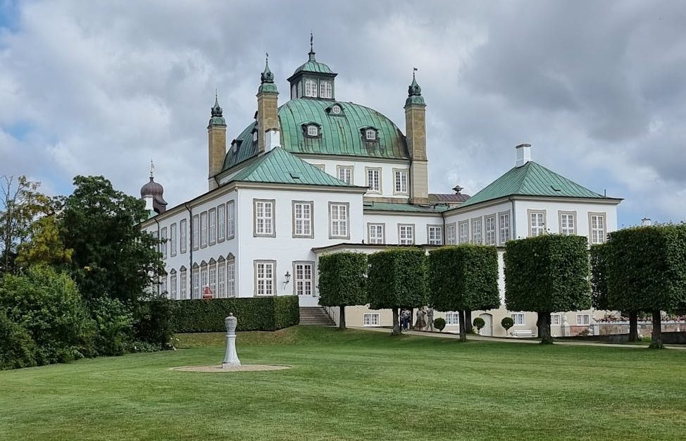 a fredensborg palace near the green grass field under the white clouds