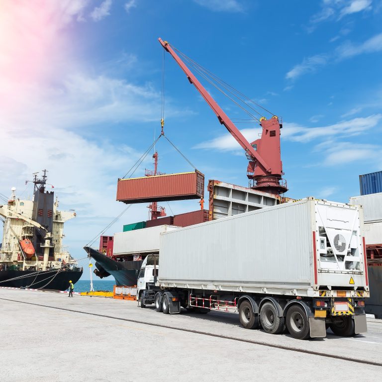 Containers in haven voor export met vrachten en kraan op achtergrond