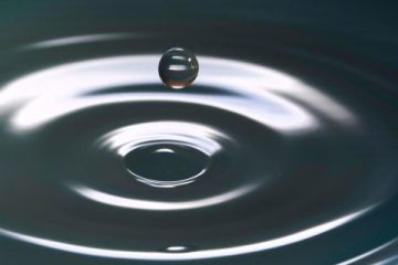 Druppel die in water valt donker beeld