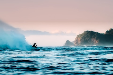 Surfend persoon bergen van kust