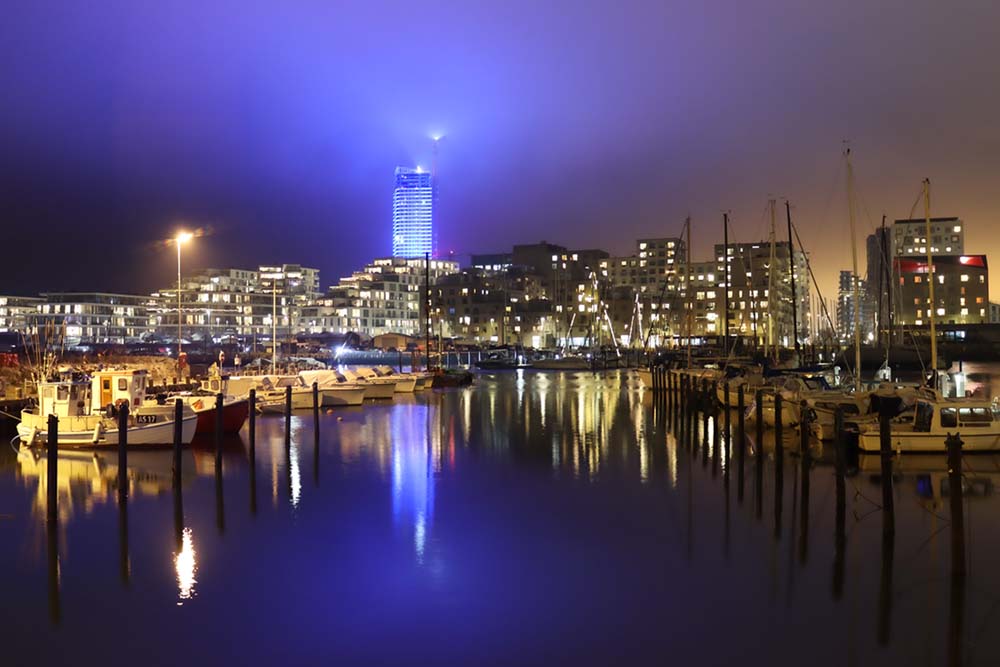 Møde mellem gamle Aarhus og nye Aarhus - her med Lighthouse, Aarhus Ø, i flot blåt lys.