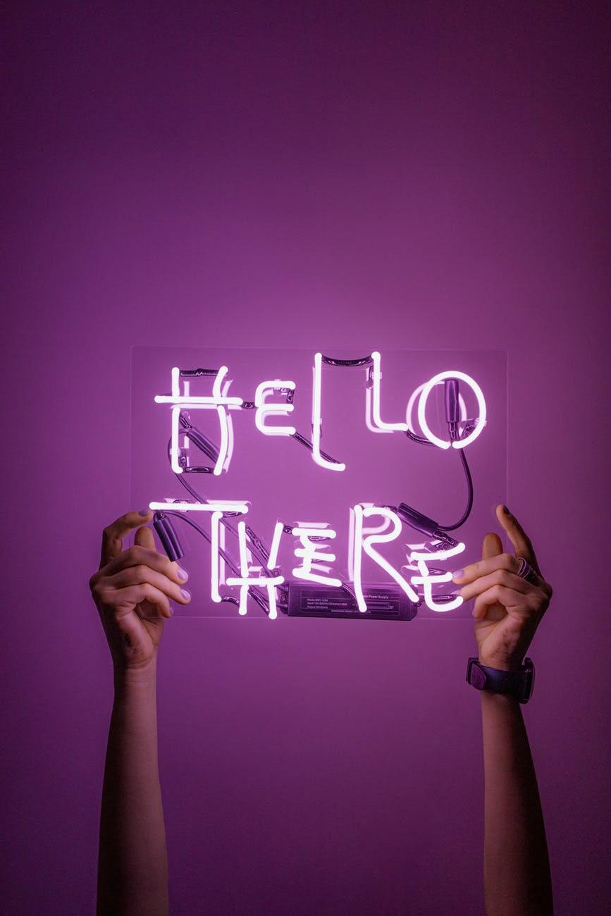 person holding a neon sign