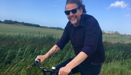 Frank op de fiets in Zeeland, blauwe lucht