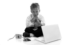 Young boy dressed as businessman with electronic gadgets - isolated on white