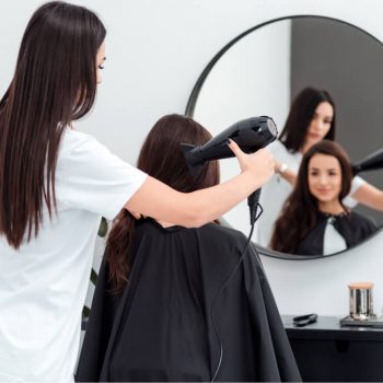 focused-hairdresser-works-drying-the-hair-of-a-bea-2021-09-24-04-23-52-utc