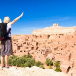 traveler arms reised in front of ait benhaddou morocco