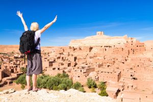 traveler arms reised in front of ait benhaddou morocco