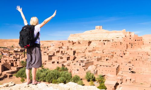 traveler arms reised in front of ait benhaddou morocco