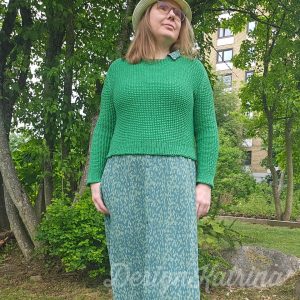 Copyright: DesignKatrina.se 
Nightingale Pullover, this version knitted by DesignKatrina. 
*A woman standing among trees with a green dress and a green knitted sweater ontop, looking to the side.*
