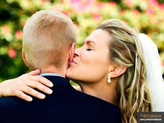 bryllupsfotograf brud kysser gom på øreflip