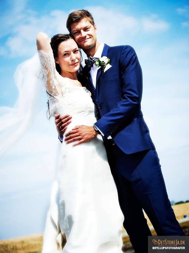 bryllupsfotografer brudepar nedefra blå himmel blæst