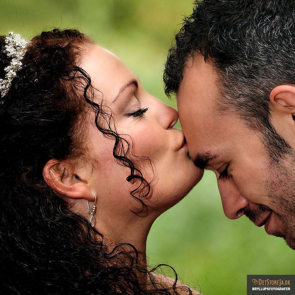 bryllupsfotograf smuk brud kysser sin gom på panden