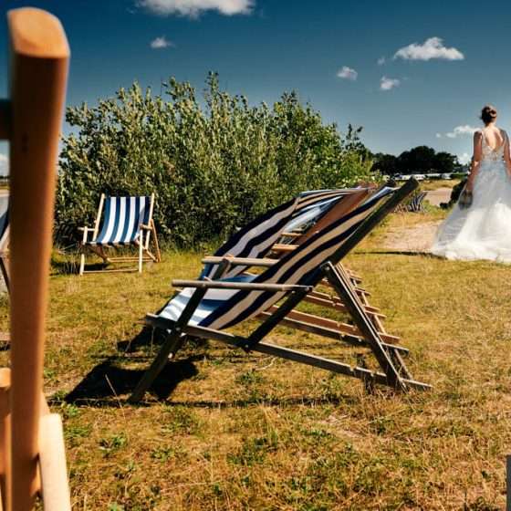 Brudepar på stranden mellem liggestole