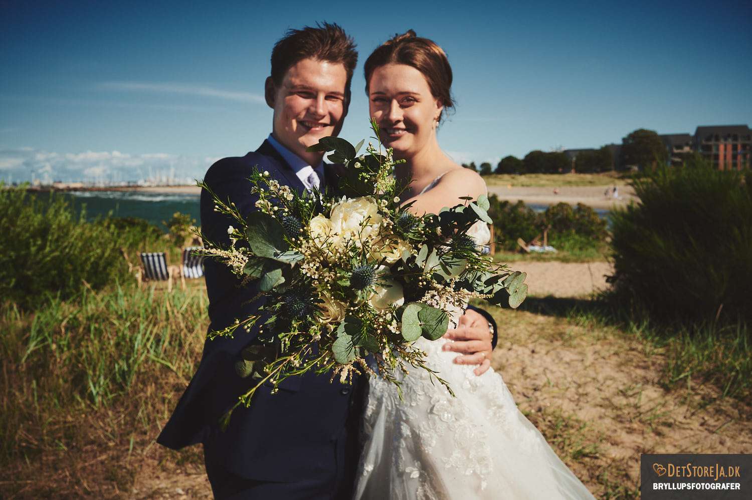 Brudepar med buket på strand