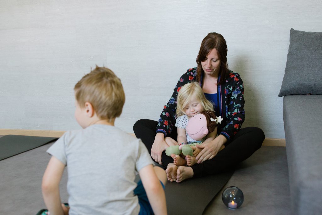 Een mama doet met haar kinderen aan kinderyoga