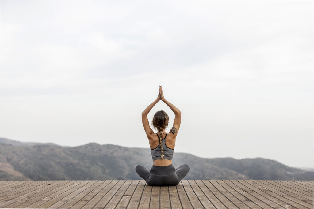 Achterkant van een vrouw die buiten yoga doet