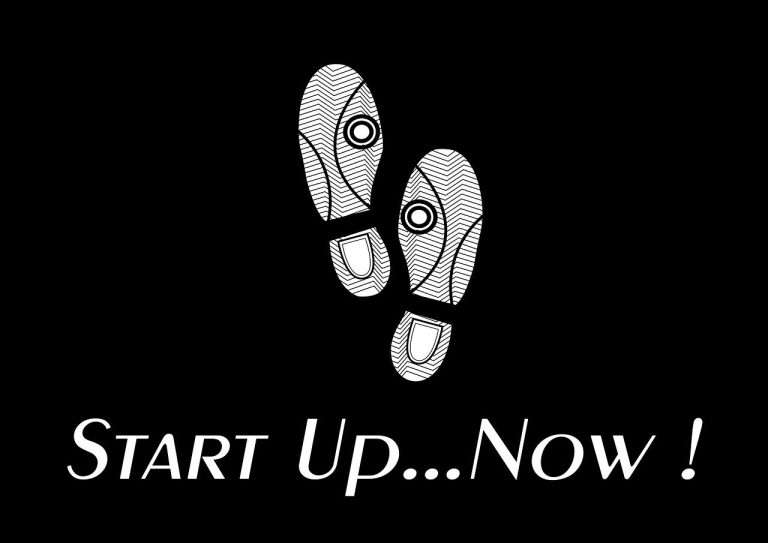 På billedet ses to sko med teksten "Start up now," symboliserende iværksætteres begyndelse. I baggrunden samles en engageret gruppe ved et mødebord, fulde af energi og kreativitet. En ung kvinde leder an, mens en ældre mentor giver vejledning om opstart af virksomhed. Sammen forfølger de deres drømme og stræber mod succes.