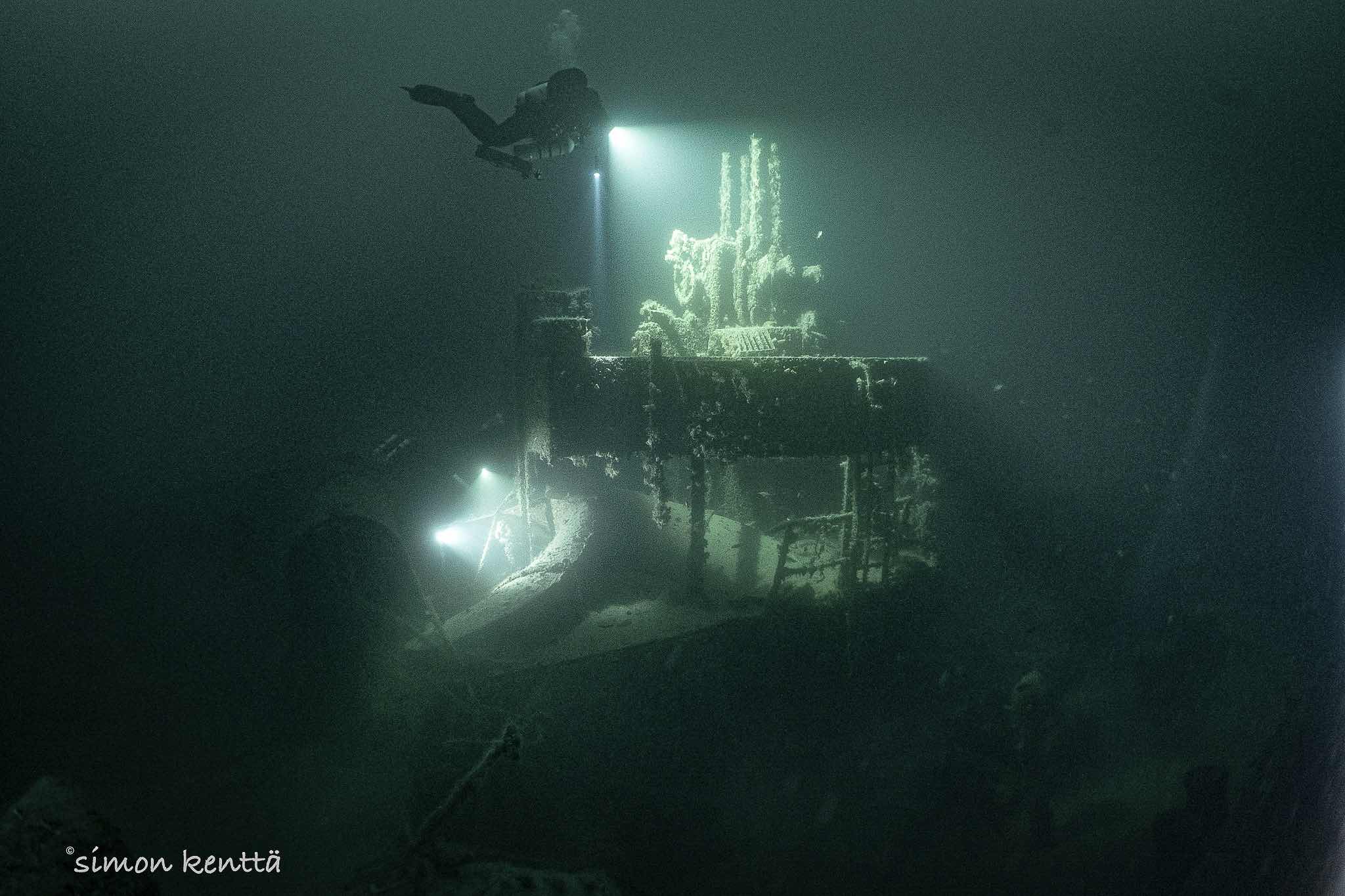 Divers check the machine gun on the Odin wreck in Narvik