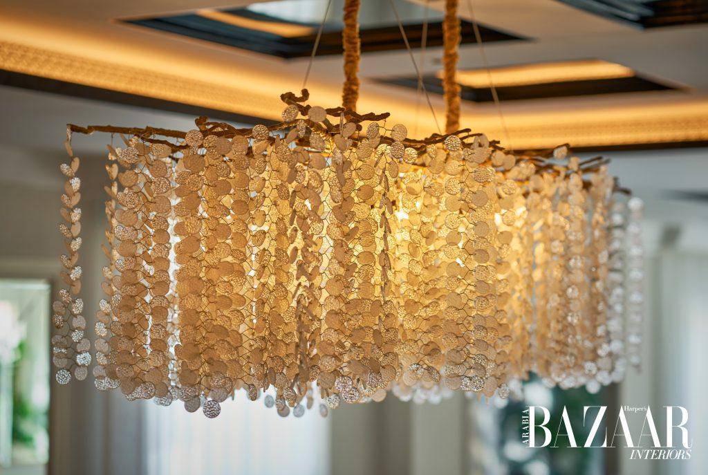 This nature-inspired chandelier has branches at the base holding elegant string-like structures that encompass multiple leaves streaming downward