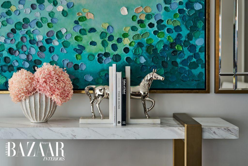 Custom artwork with petal-like motifs and horse bookends further highlight the theme of nature in the living area