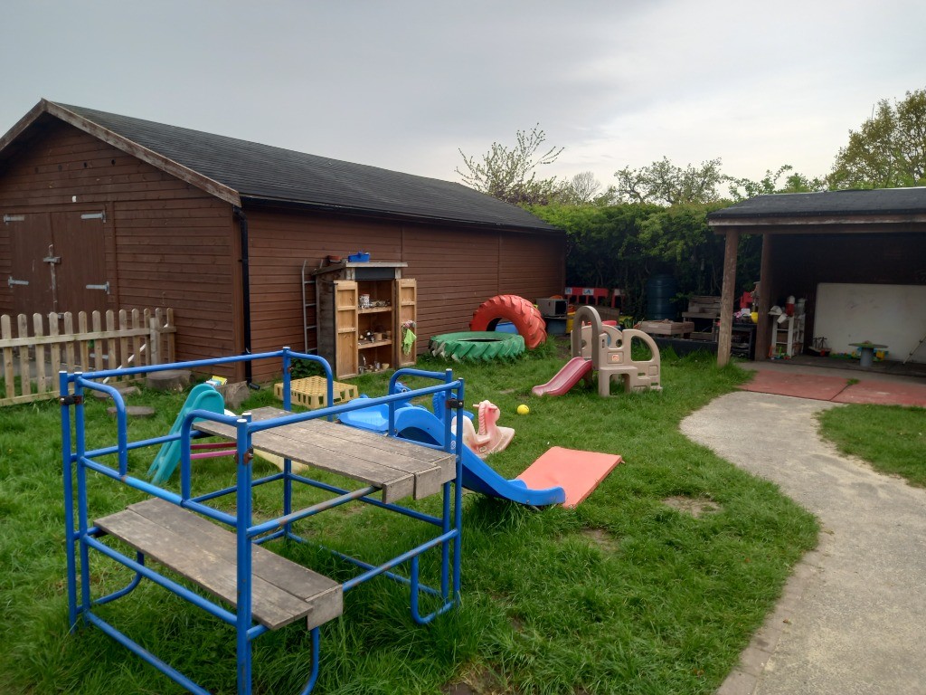 Children's climbing frames and slides outside at Dodleston Pre-School
