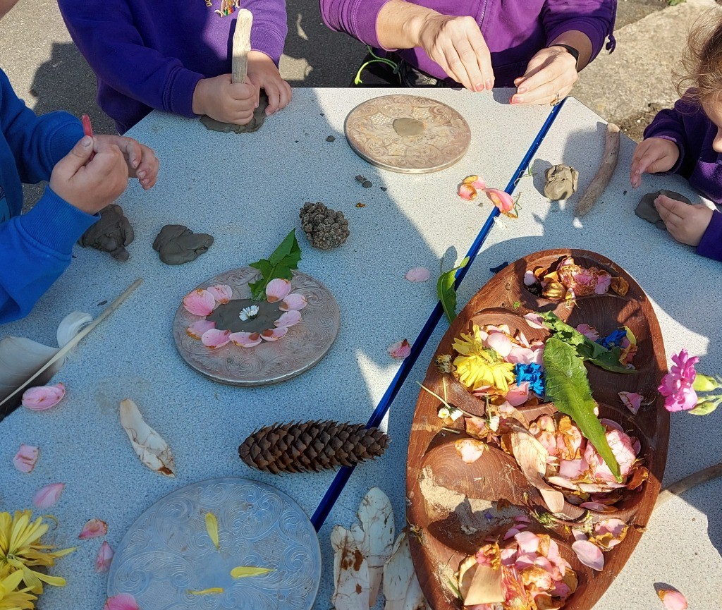 Children playing with pinecones and leaves outside