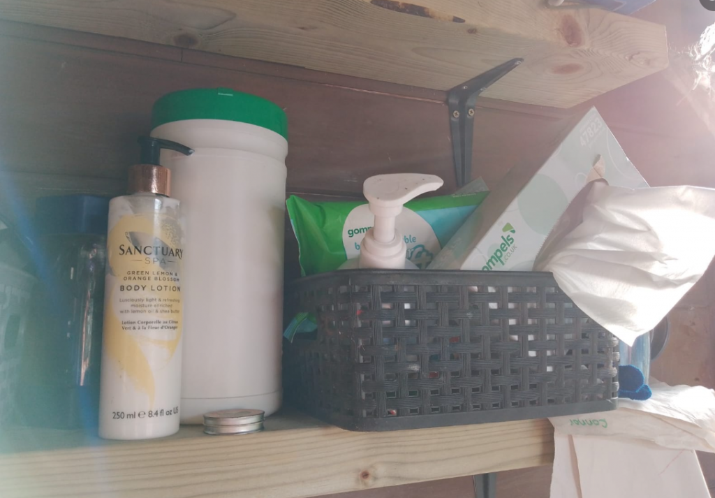 A shelf of supplies, including hand gel and wipes