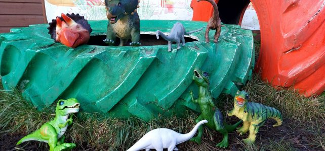 The herd of donated dinosaurs sat inside a green tyre