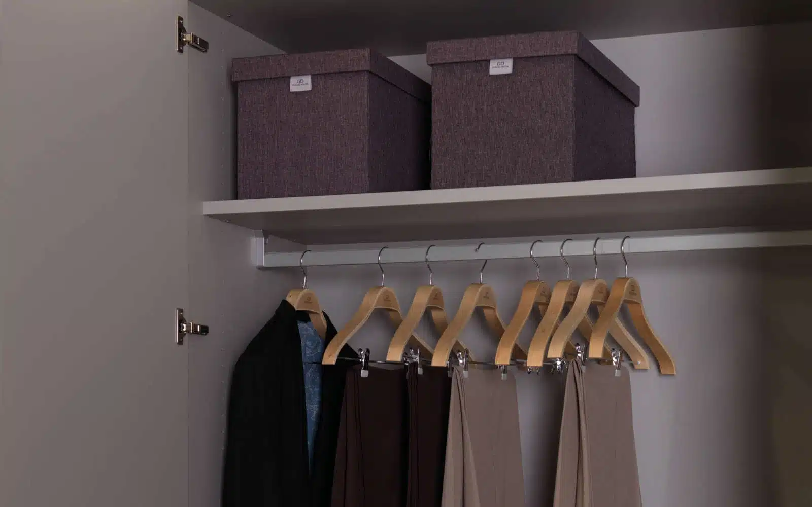 Et billede af en garderobe i grå laminat med to skydedøre og en hængestang til tøj. Garderoben har en enkel og moderne stil med rene linjer og en glat overflade, Garderoben kan købes hos DOKK16, en møbelbutik beliggende i Aarhus, Jylland. DOKK16 er kendt for at tilbyde moderne og stilfulde møbler til overkommelige priser, opbevaringskasser