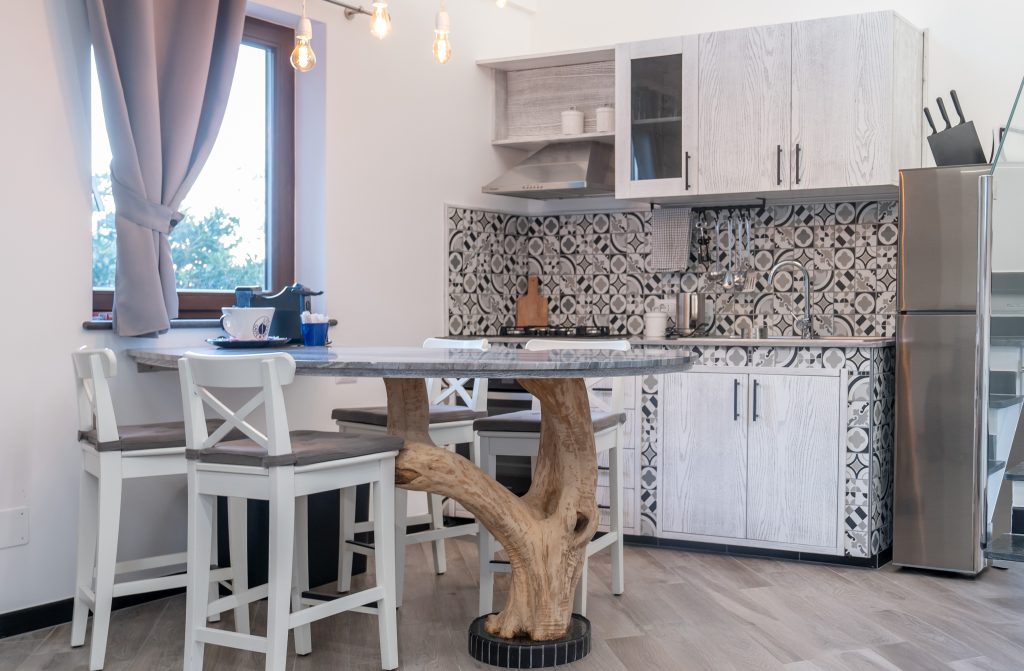 Kitchen with patterned tiles and olive wood table