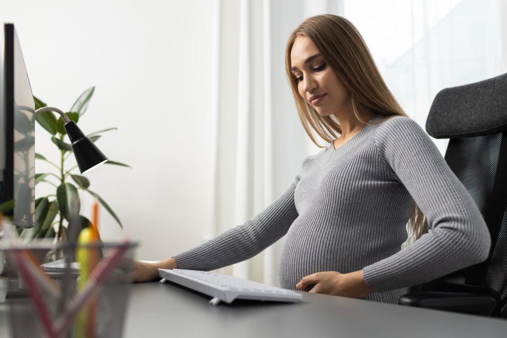 vue-laterale-femme-affaires-enceinte-au-bureau