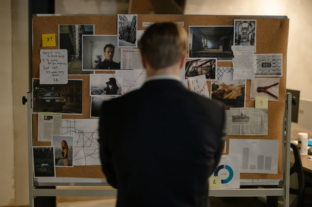 Man standing in front of wall with pictures