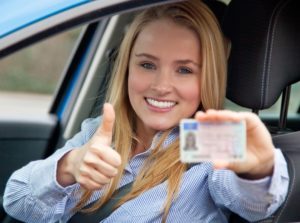 Jonge vrouw blij want ze heeft haar rijbewijs gehaald