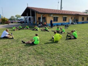 U15-drengene ude ved deres bane med klubhus og ambulance i baggrunden