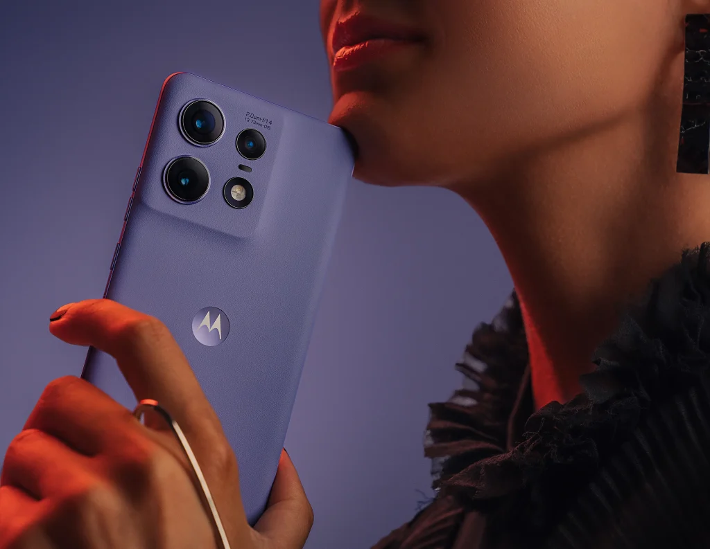 Pige med røde læber holder Motorola Edge 50 Pro i hånden.