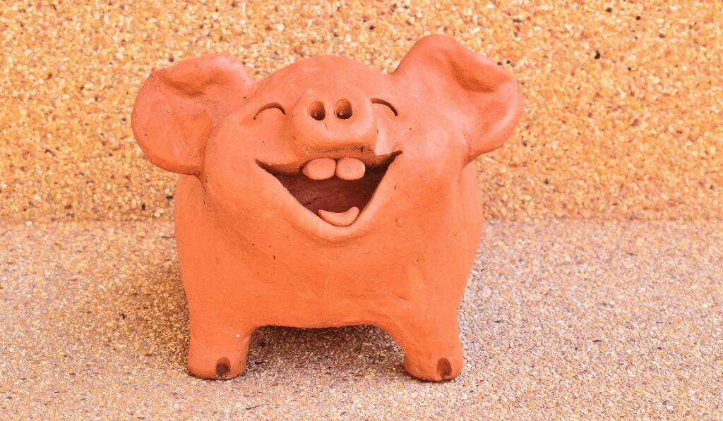 Lachendes rosa Glücksschwein aus Ton geformt