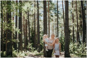 Mamma med döttrar blir fotograferade i skogen