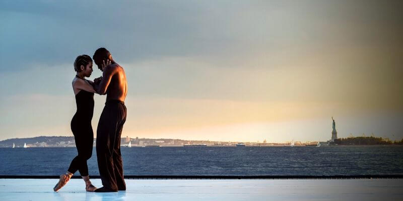 una coppia di ballerini sullo sfondo della statua della libertà
