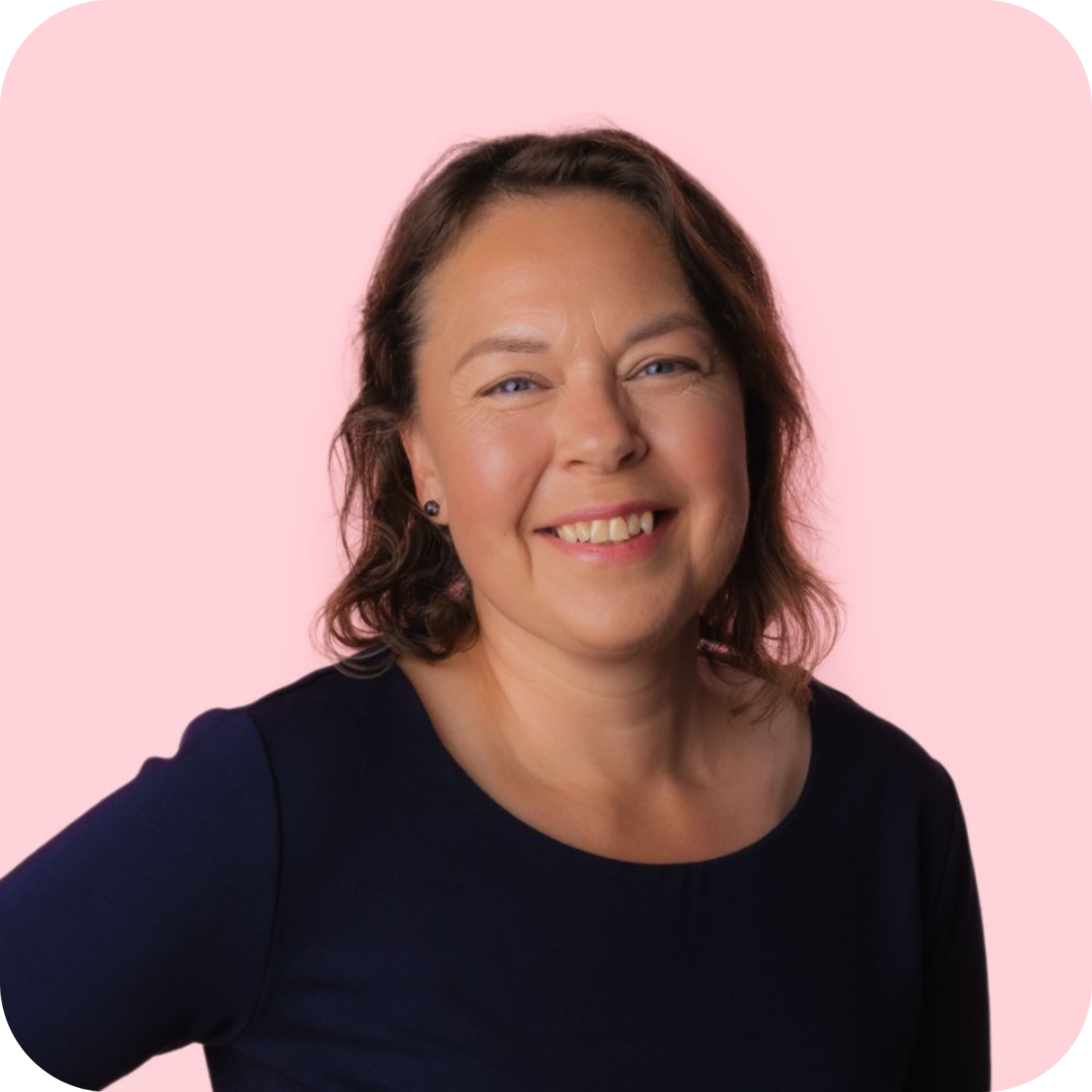 Portrait of smiling woman against pink background