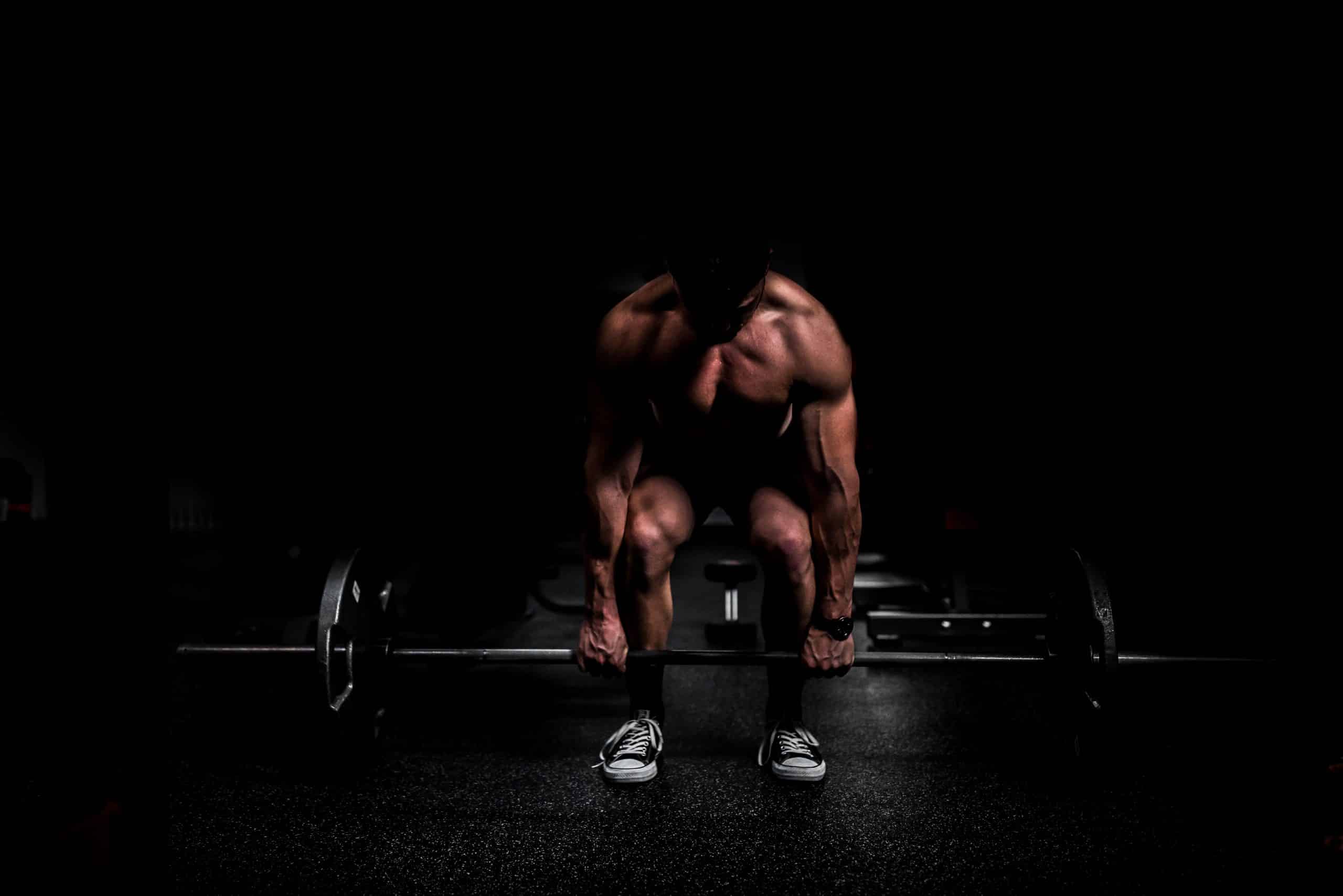 Guy in leisure centre lifting barbell