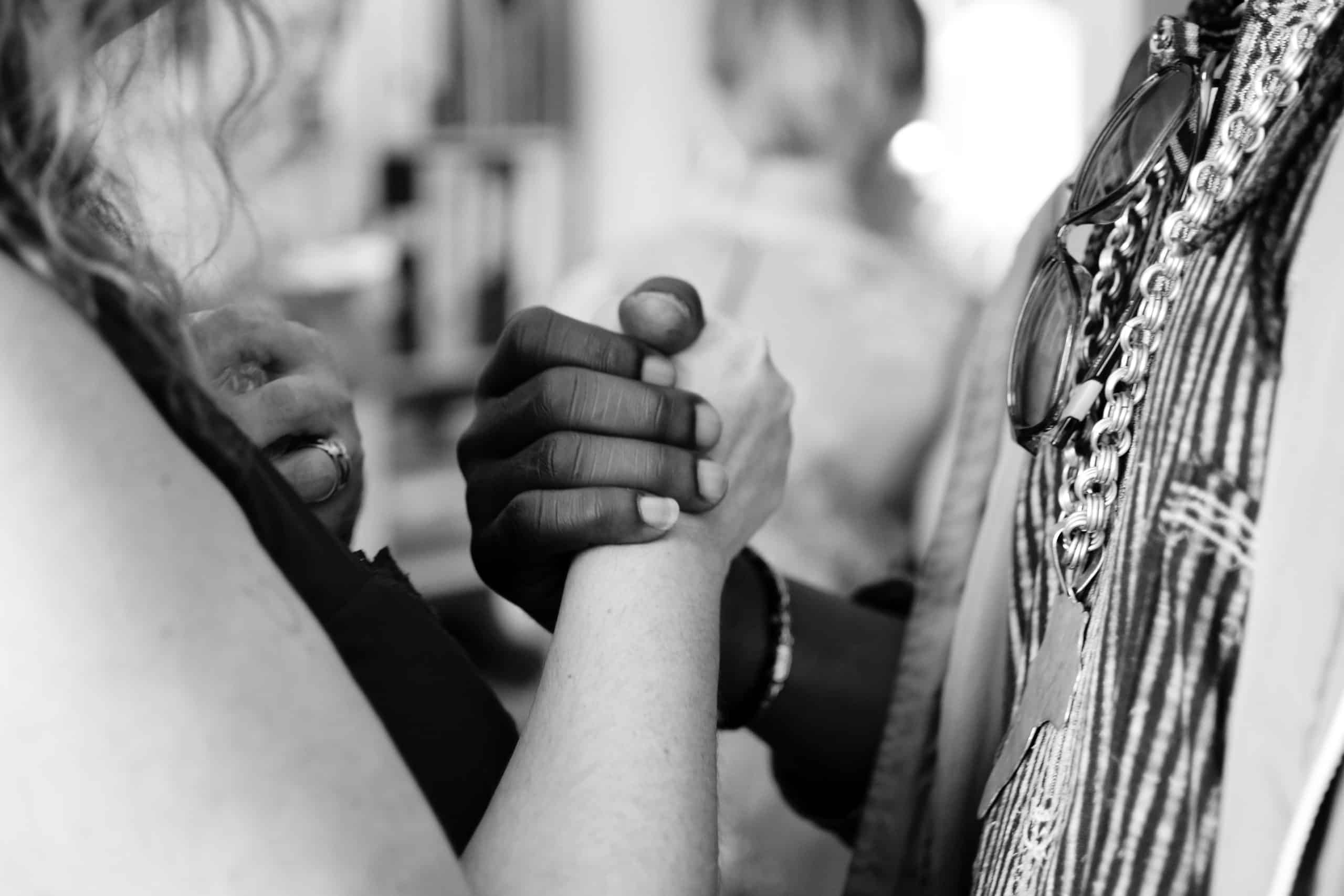 Two people shaking hands of different races - showing empathy towards each other