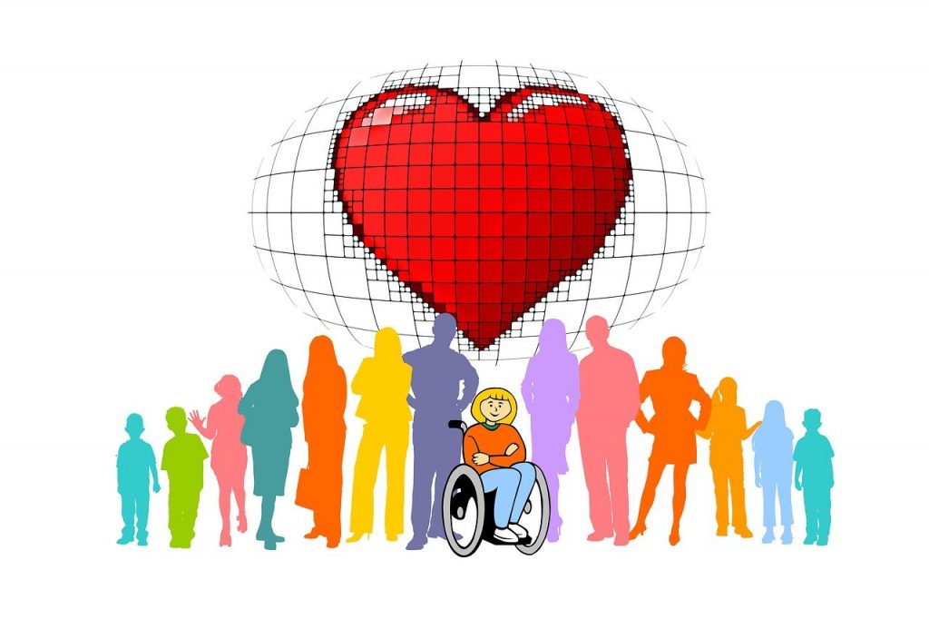 Foto con un grande cuore rosso sopra a molte persone di colore azzurro, verde, rosa, arancione, giallo e fuxia. Nel mezzo una ragazza siede sulla sedia a rotelle.