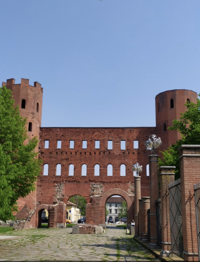 Il reperto più straordinario dell’epoca è senza dubbio la Porta Palatina, locata di fronte al teatro. Questa rappresentava l’accesso settentrionale alla civitas Romana ed è una delle porte urbiche meglio conservate al mondo. Se questo non bastasse a convincervi della sua maestosità vi invito ad attraversare le sue arcate. Così come già descritto in merito alla Porta Decumana, anche la Palatina è composta da quattro archi di ingresso, due per i carri e due per i pedoni.