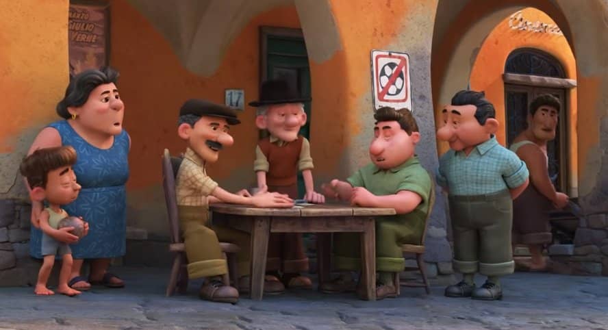 Frame del nuovo film disney pixar Luca in cui se vedono gli anziani del borgo giocare a scacchi, alle loro spalle il cartello indica il divieto di giocare a palla nella piazza, cartello che si ritrova in moltissime piazze in liguria