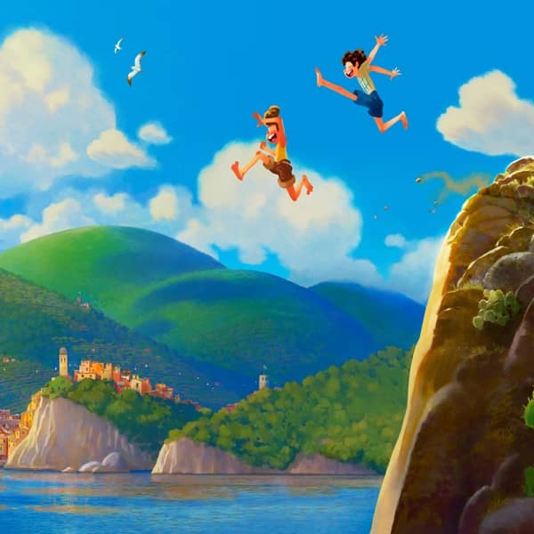 Frame del nuovo film Disney Pixar Luca, i due protagonisti si tuffano in mare saltando da una scogliera mentre sullo sfondo vediamo il piccolo borgo di Portorosso, ispirato alle 5 terre