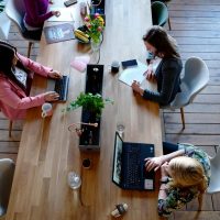 Overhead view of diverse women professionals working in a modern office setting, fostering collaboration and teamwork.